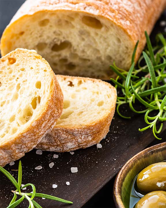 fette di pane su tagliere pronte per essere condite con olio pugliese